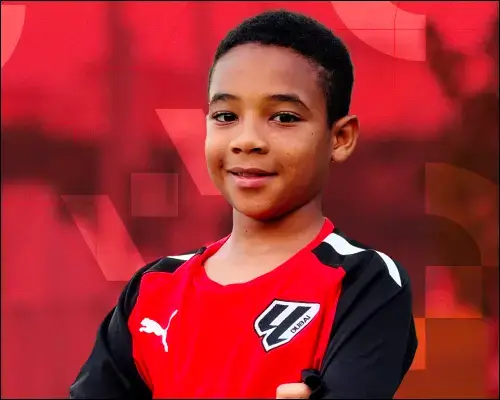 A young boy in a red and black soccer uniform at Open Trials in LaLiga Academy Dubai. A young boy in a red and black soccer uniform at Open Trials in LaLiga Academy Dubai.